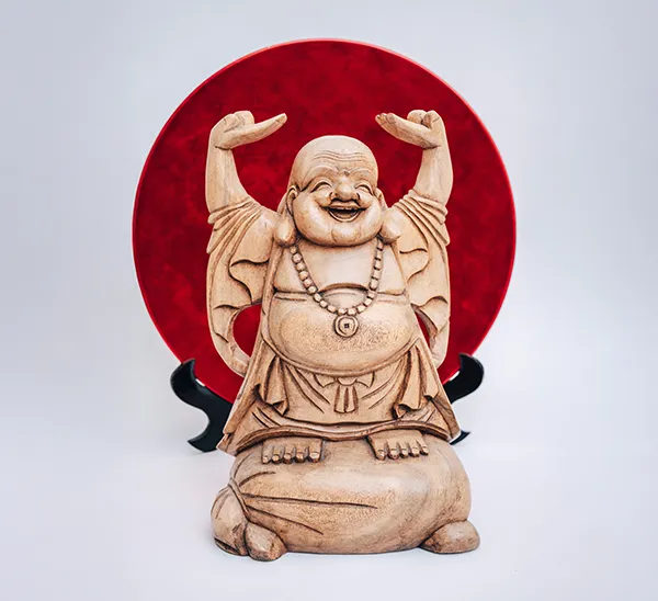 Lächelnder Buddha vor einem roten Teller