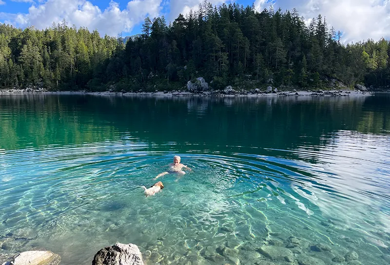 Rainr Weber schwimmt mit seinem Hund im See.